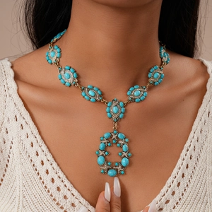 Gros plan d'un collier rétro avec pierres en résine turquoise et strass sur un mannequin