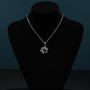 Polished silver cat paw pendant on a delicate chain shown on a black display stand