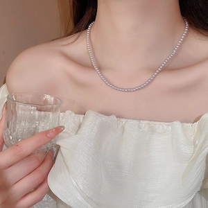 Close-up of elegant pink pearl necklace worn by a model in a luxury setting