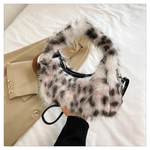Detailed close-up of fluffy leopard print plush crescent bag with black leather strap
