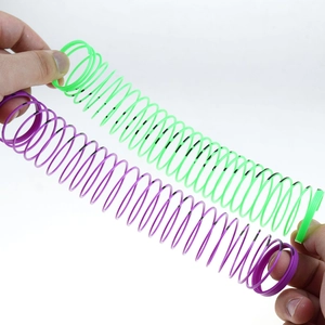 Detailed view of flexible plastic spring toy being stretched in purple and green colors