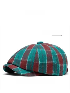 Close-up of green and red plaid fabric texture on a wool blend newsboy cap