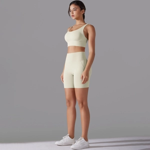 Vista laterale del set fitness giallo pallido con reggiseno sportivo e pantaloncini yoga