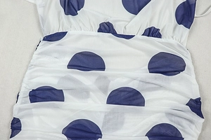 Detail of white mesh fabric with blue polka dots and pleated ruching textures
