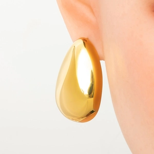 Close-up of golden hollow drop earrings showing polished finish and modern teardrop style
