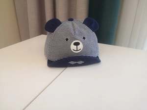 Close-up of blue and white striped baby sun hat with cute 3D bear ears and embroidery