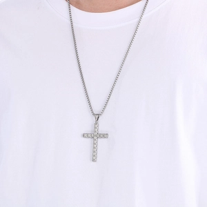 Pendentif croix en acier inoxydable argenté porté par un mannequin sur t-shirt blanc