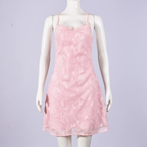 Detailed texture of pink mini dress featuring 3D floral embossed fabric and neck straps