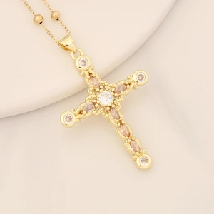 Detailed close-up of 18K gold-plated cross pendant with champagne zircon crystals
