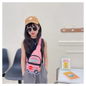 Pink school bus shaped chest bag for kids worn by model in a bright modern setting