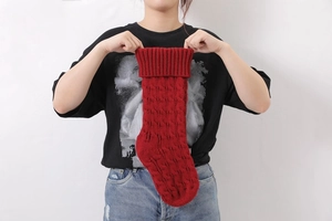 Detail of red cable knit Christmas stocking showing thick yarn texture and ribbed cuff