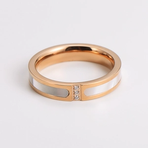 Detail eines Edelstahlrings in Roségold mit weißer Einlage und drei zentralen Zirkonia
