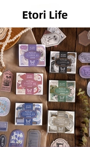 Close-up of vintage floral stickers with gold stamping on dark wood texture background