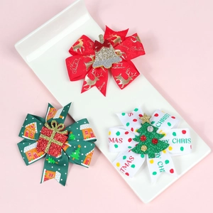 Detailed view of three handmade Christmas hair bows with reindeer and tree patterns