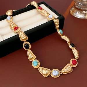 Detail view of vintage gold necklace with colorful round gemstones in a black gift box