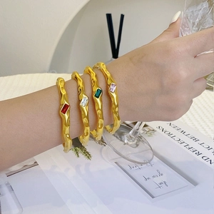 Set of four gold hammered stainless steel cuffs with colorful rectangular zircon gemstones