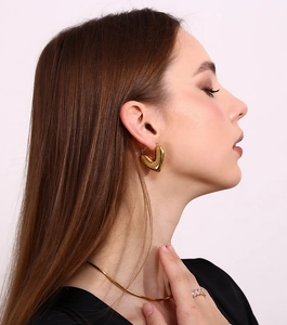 Detailed view of gold 18K plated heart earrings with matching snake chain necklace