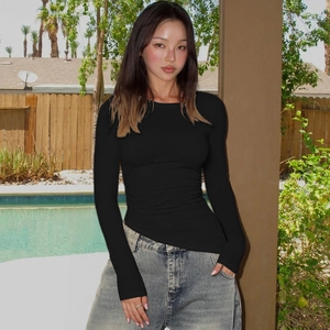 Haut moulant noir à manches longues pour femme porté avec un jean bleu classique