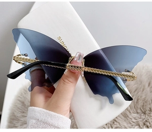 Close-up of butterfly sunglasses with blue gradient lenses and golden chain temples