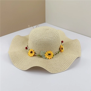 Wide brim wavy straw sun hat with sunflower garland for beach vacations and summer sun protection
