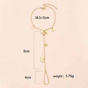 Detailed view of gold chain finger bracelet with star and butterfly charms and dimensions
