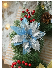Detail of blue poinsettia christmas flower with silver glitter and red berries