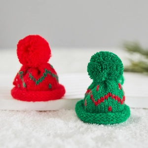 Mini knitted Christmas hats in red and green with pompom for holiday tree decorations