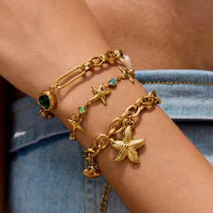 Layered titanium steel bracelet with starfish pendants and green gemstones on wrist