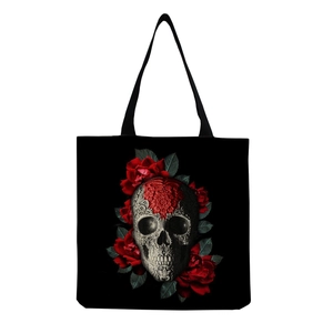 Detailed view of skull and red roses print on black canvas tote bag surface
