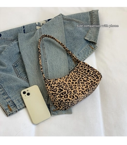 Détail du sac léopard sous le bras avec un smartphone pour référence de taille