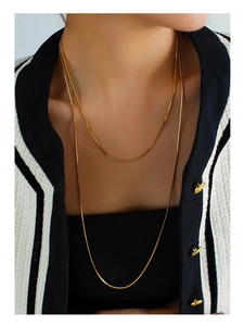 Close-up of dual-layer 18K gold-plated snake bone chain necklace on a model's neck