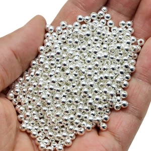 Macro shot of a handful of silver round metal spacer beads for DIY jewelry making
