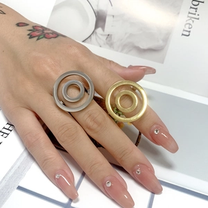Detail of minimalist gold and silver round concentric rings worn on hand for styling