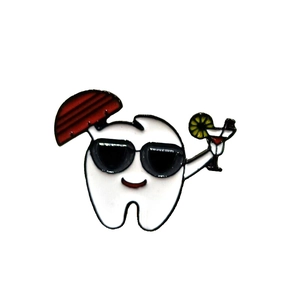 Detail of creative enamel tooth pin with sunglasses, cocktail, and umbrella