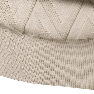 Detailed macro view of the warm beige knitted fabric with geometric V-pattern and ribbed cuffs