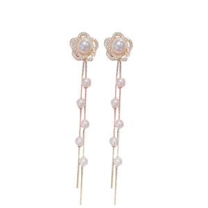 Elegant gold flower tassel earrings with pearls and crystals on white background