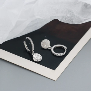 Detail view of 925 silver star and moon earrings with small zircons on black card