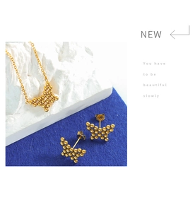 Close-up of golden butterfly jewelry set on blue velvet and white stone texture