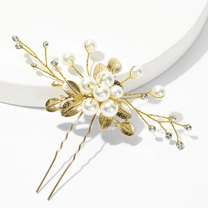 Detailed close-up of handmade bridal hair pin with white pearls and golden floral leaves