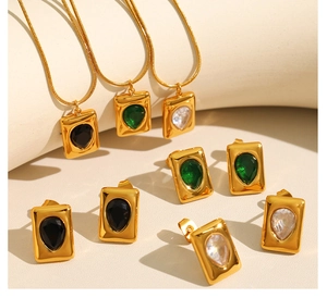 Detailed macro view of 18K gold plated jewelry set with teardrop emerald crystals