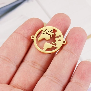 Polished gold world map pendant connector in hollow globe design shown on fingertip