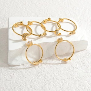 Set of 6 gold rings with stars, moons and rhinestones on white display blocks