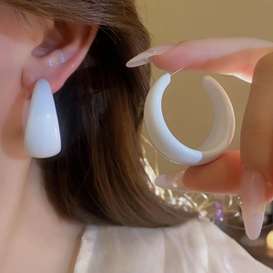 Boucles d'oreilles créoles blanches en forme de C avec finition brillante sur l'oreille