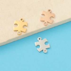 Polished puzzle piece pendants in gold, rose gold and silver with sparkling rhinestones