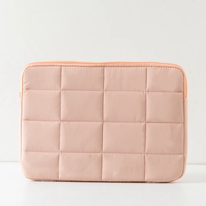 Detailed view of pink quilted laptop sleeve with soft padding and matching top zipper