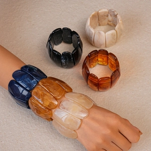 Macro shot of wide acrylic resin bangles with marble texture in earth tones