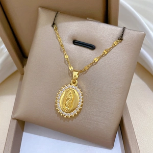 Macro shot of gold Virgin Mary oval pendant with sparkling zircon bezel on beige cushion