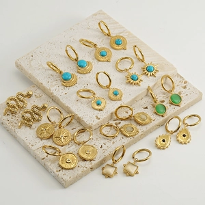 Détail de boucles d'oreilles en or 18 carats avec turquoise et cristal, style bohème