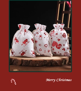 Detail of white linen wedding favor bags with red heart patterns and Love text
