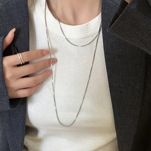 Silver layered long sweater necklace shown with grey suit and white inner garment
